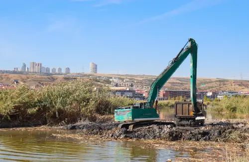Un engin de chantier nettoie le lit d'une rivière après une inondation.